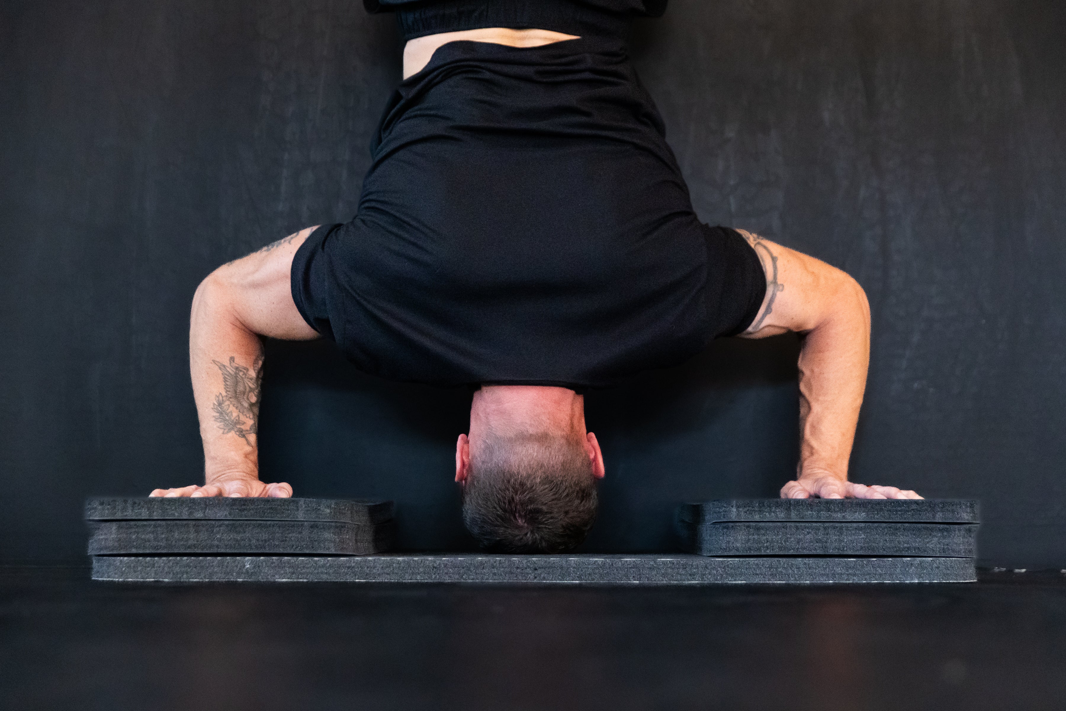 man doing handstand pushups with urlnd risers